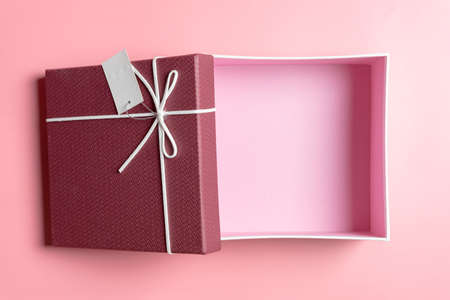 Red gift box, ribbon bundle on pink background