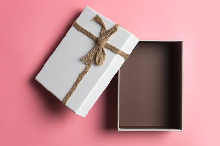 White gift box, ribbon bundle, cotton rope, placed on pink background.の写真素材