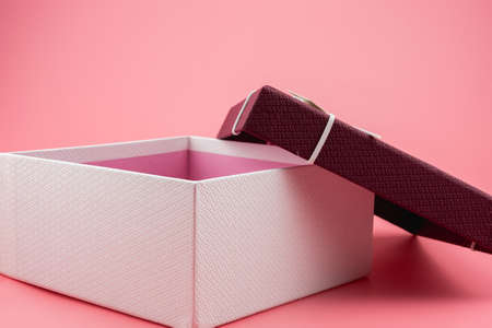 Red gift box, ribbon bundle on pink backgroundの写真素材