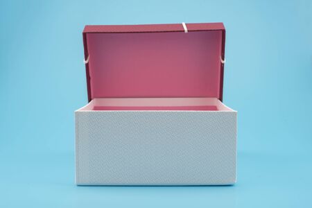 Red gift box, ribbon bundle, placed on a blue background.