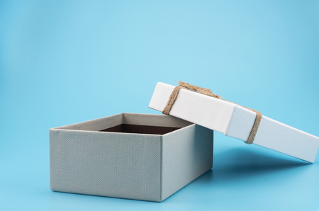 White gift box, ribbon bundle, cotton rope, placed on a blue background.の写真素材