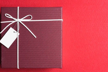 Red gift box, ribbon bundle on red backgroundの写真素材