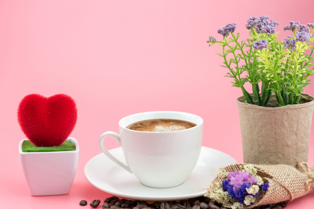 coffee cup with cofee beans and flower on pink background. の写真素材