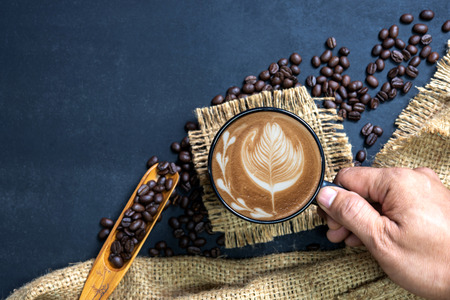  cup of coffee on black table. Top view mockup a cup of coffee with coffee beans and hemp sack  on...