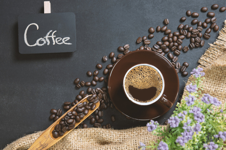 cup of coffee on black table. Top view mockup a cup of coffee with coffee beans and hemp sack  on the black stone.の写真素材