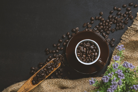 cup of coffee on black table. Top view mockup a cup of coffee with coffee beans and hemp sack  on the black stone.の写真素材