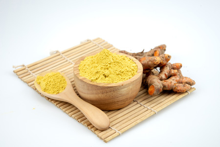 Turmeric powder and fresh turmeric on white background.