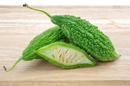 Bitter melon or Bitter gourd with half sliced on wooden background. bitter gourds.の写真素材