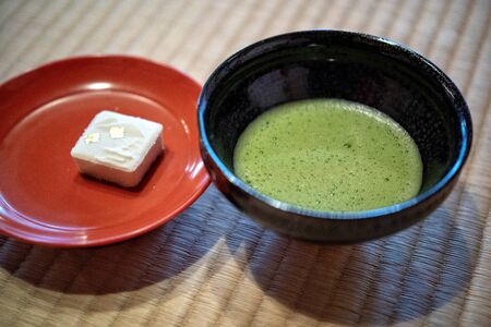 Japanese green matcha tea  top view. Japanese matcha green tea latte in black bowl on  background....
