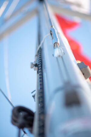 Turnbuckle on a Sailing Boat. sail yacht mast close-up. Top of yacht: mast and sail filled by the wind. The wind has filled the spinnaker on sailing yacht.の写真素材