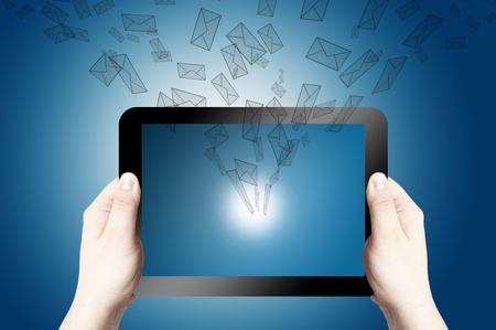 Hands holding on digital tablet with 3D mail icon coming from the screen on blue backgroundの写真素材
