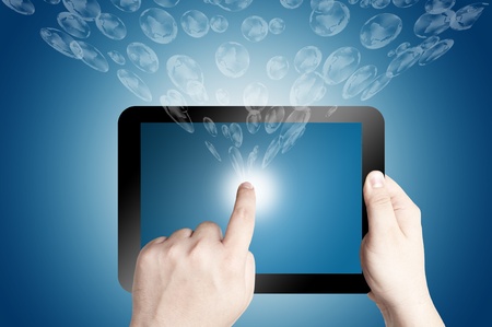 Hand holding and pointing on digital tablet with 3D globe icon coming from the screen on blue backgroundの写真素材