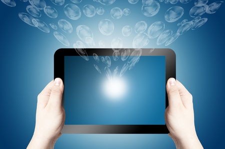 Hands holding on digital tablet with 3D globe icon coming from the screen on blue backgroundの写真素材