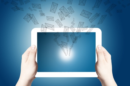 Hands holding on digital tablet with 3D mail icon coming from the screen on blue backgroundの写真素材