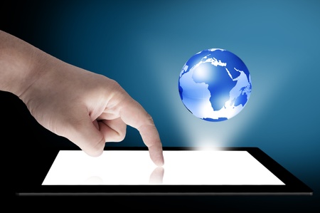 Businessman touch tablet PC screen with blue internet globe coming out from the screen  Concept for internet and connectivityの写真素材