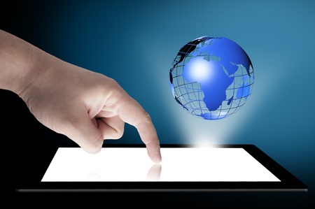 Businessman touch tablet PC screen with blue internet globe coming out from the screen  Concept for internet and connectivityの写真素材