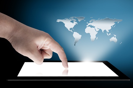 Man s finger pointing on the touch screen tablet PC with 3D world map raising from the screen  Concept for connectivityの写真素材