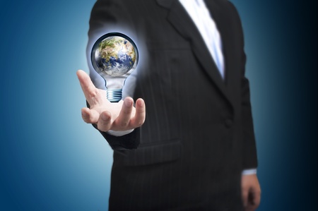 Business man with the digital globe ball inside light bulb floating on his hand  Concept for connectivity, communication within grasp  の写真素材