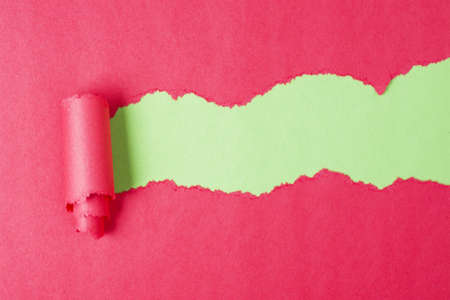 Torn red color paper on green backgroundの写真素材