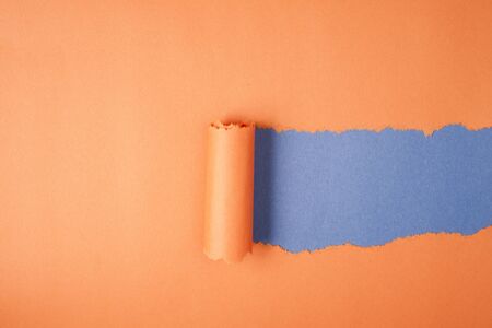 Orange Tear Paper on blue backgroundの写真素材