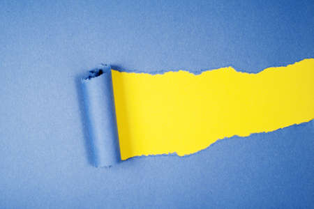 Blue Tear Paper on yellow backgroundの写真素材