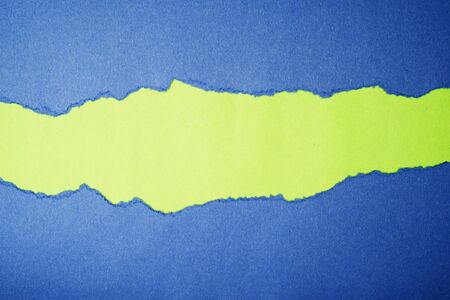 Blue Tear Paper on green backgroundの写真素材