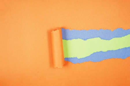 Orange Tear Paper on green and blue backgroundの写真素材
