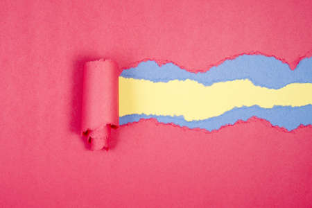Red Tear Paper on yellow and blue backgroundの写真素材
