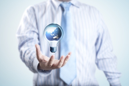 Business man with the digital globe inside light bulb floating on his hand  Concept for idea of connectivity within grasp の写真素材
