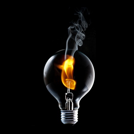 Fire and smoke in side the light bulb  Concept for energy consumption and environmental awareness の写真素材