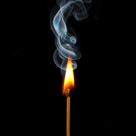 Spark of match with fire and smoke on black backgroundの写真素材