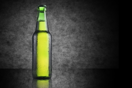 Cold green bottle of beer on black backgroundの写真素材