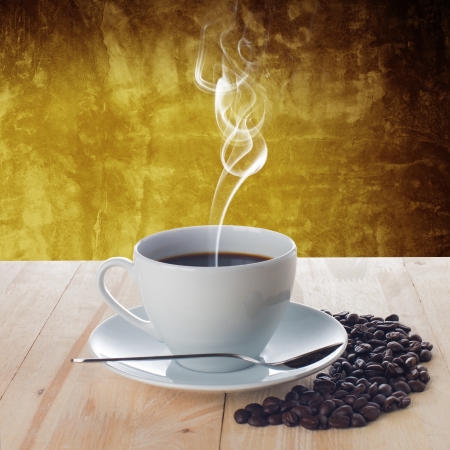 Hot cup of coffee with smoke on wood table with grunge backgroundの写真素材