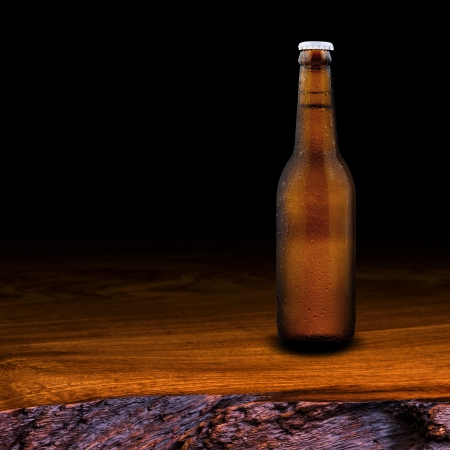Bottle of beer on wood table on black backgroundの写真素材