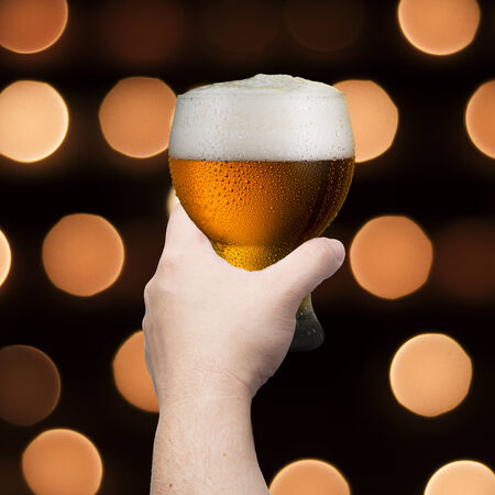 Hand holding glass of beerの写真素材