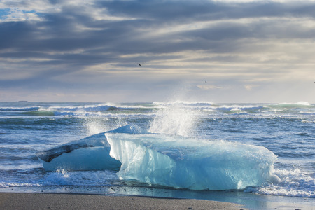 Ice on ice beach with water wave in Jokulsarlon, Iceland