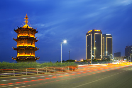 Wuhu city China-Aug 15:Chinese pagodas and Double tree building beside Yang ci river,long time exposure,focus on chinese pagodas,Aug 2015 wuhu city,Chinaのeditorial素材