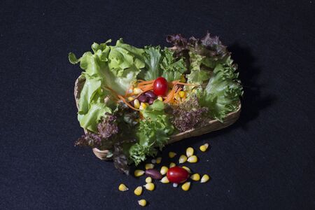 Healthy food. Fresh green salad on black backgroundの写真素材