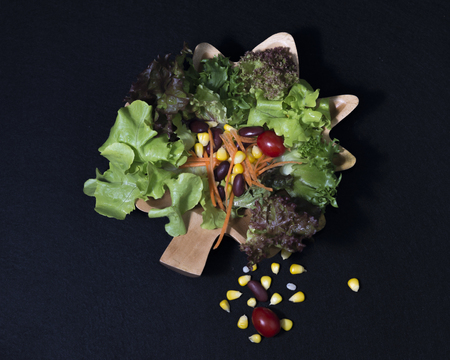 Healthy food. Fresh green salad on black backgroundの写真素材