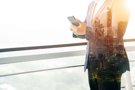 Asian business man used mobile in office, double exposure photography.の写真素材