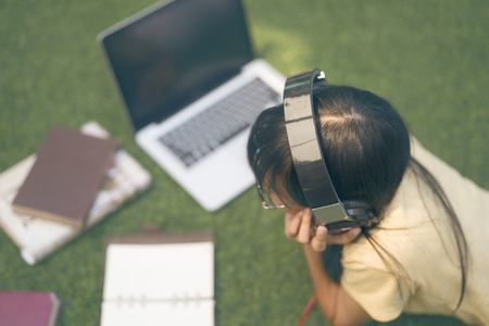 Young asian woman reading books and work with laptop and listening music in home or coffee shop , retro style.の写真素材