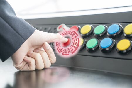 Woman pushing red or emergency button on dash board for stop machine.