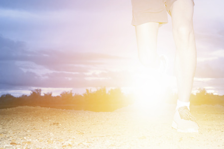 Man jogging or running on jungle trail with sunset.の写真素材