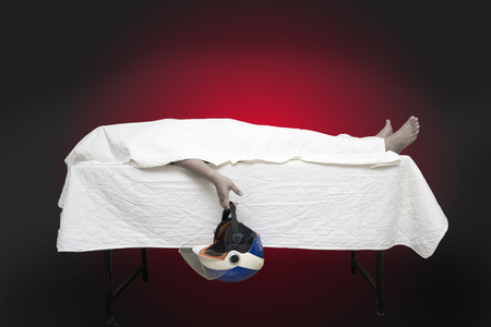 Dead man on bed with helmet.Safety ride concept.の写真素材