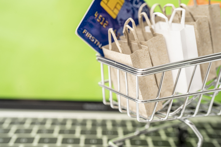 Selling or buying online,shopping online or e-commerce with paper box ,paper bag and credit card in shopping cart or trolley.の写真素材
