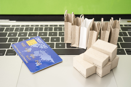 Selling or buying online,shopping online or e-commerce with paper box ,paper bag and credit card in shopping cart or trolley.の写真素材