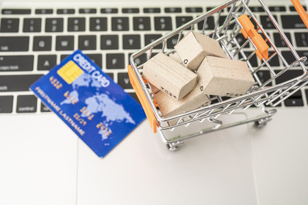 Selling or buying online,shopping online or e-commerce with paper box ,paper bag and credit card in shopping cart or trolley.の写真素材