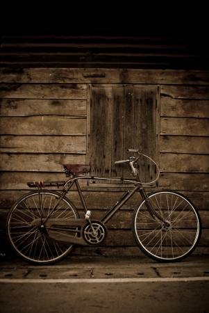 old style brown bicycle and wood doorの写真素材