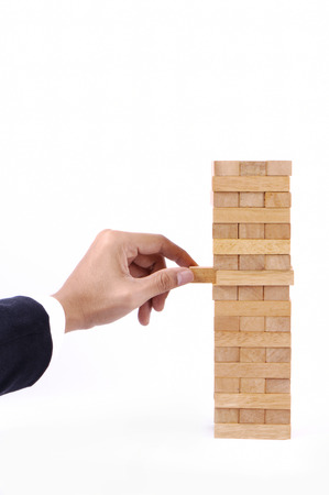 Businessman Hand playing with the wood game (jenga).の写真素材