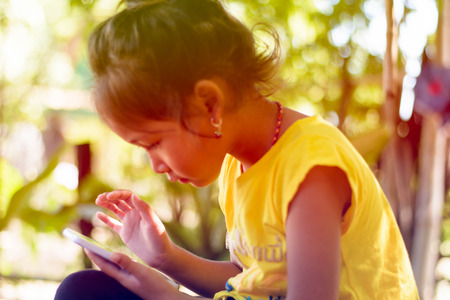 child girl happy look smart phone. asian childの写真素材
